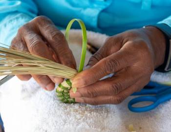 A Gullah Geechee person weaving a traditional basket for the Hilton Head Island Gullah Celebration