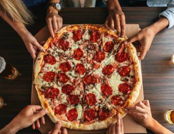 Friends grabbing slices of pizza on Hilton Head Island