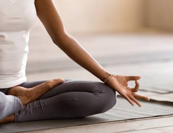 woman meditating and practicing yoga at a studio