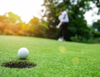golf ball about to sink into hole